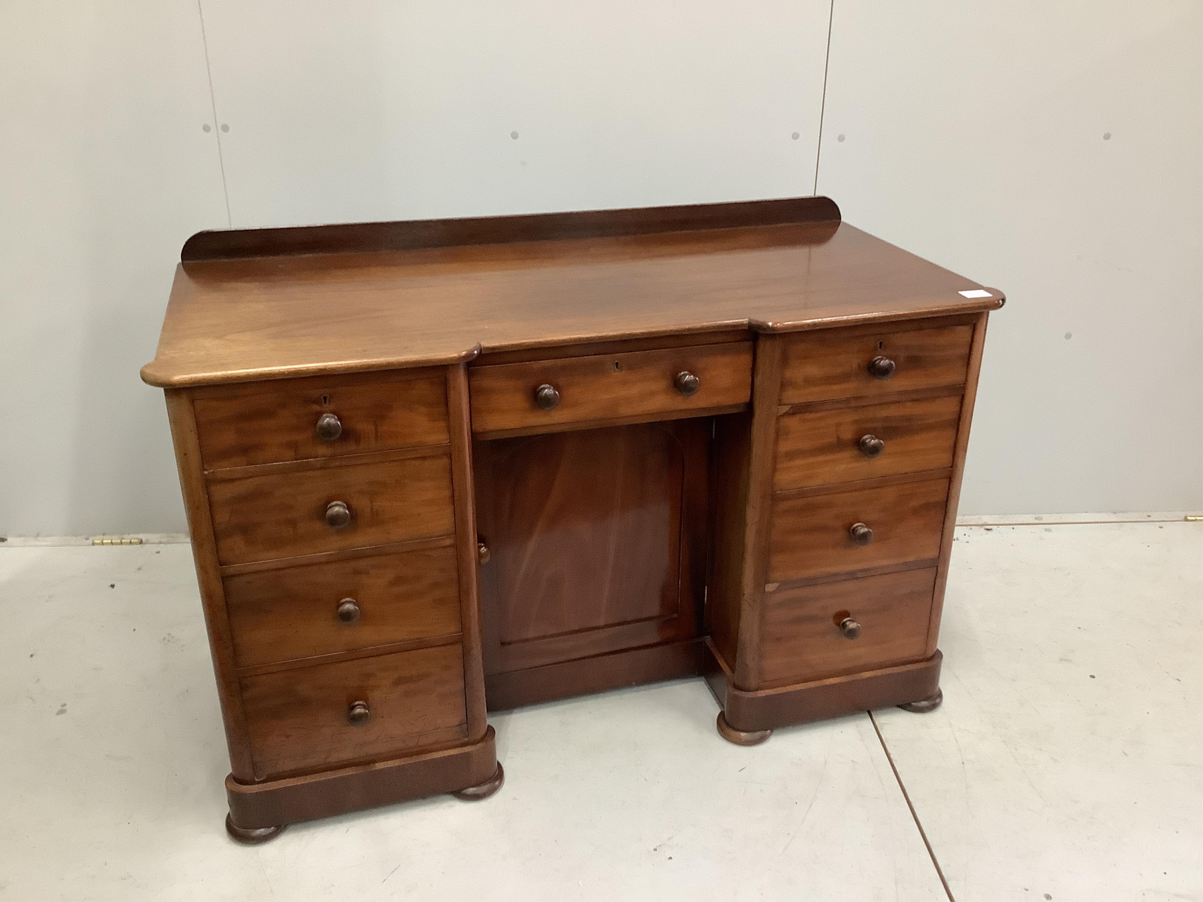 A Victorian mahogany kneehole desk, fitted nine small drawers, width 125cm, height 78cm. Condition - faded to one side, otherwise good